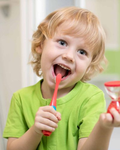 Happy,Kid,Boy,Brushing,Teeth,Near,Mirror,In,Bathroom.,He
